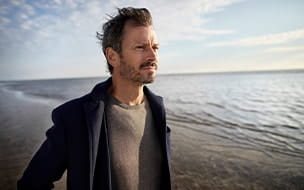 Man at the beach looking thoughtful