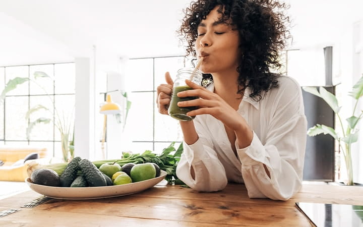 Young woman drinking a green smoothie