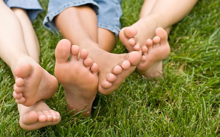 Several pairs of bare feet in the grass