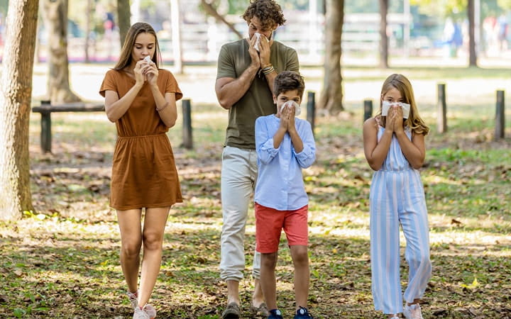 Family walks outside blowing noses