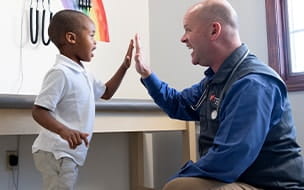 Kevin Turner, MD gives his young patient a high five