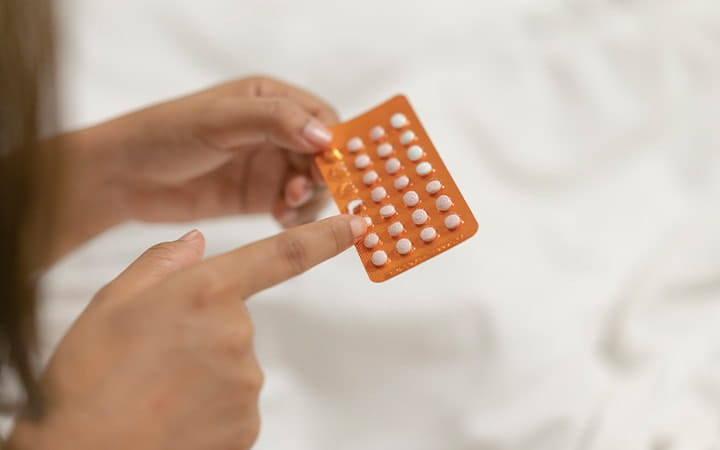 woman holding birth control pills