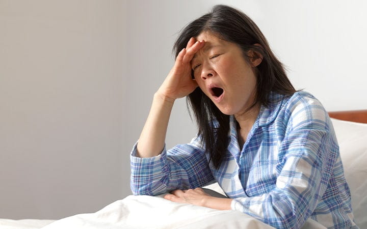 A woman yawning in bed