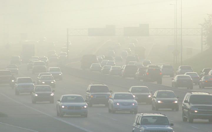 Cars at rush hour driving through thick smog