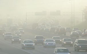 Cars at rush hour driving through thick smog