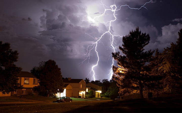 Lightning flashes over a neighborhood at night