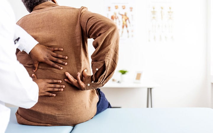 Doctor examining a mans lower back