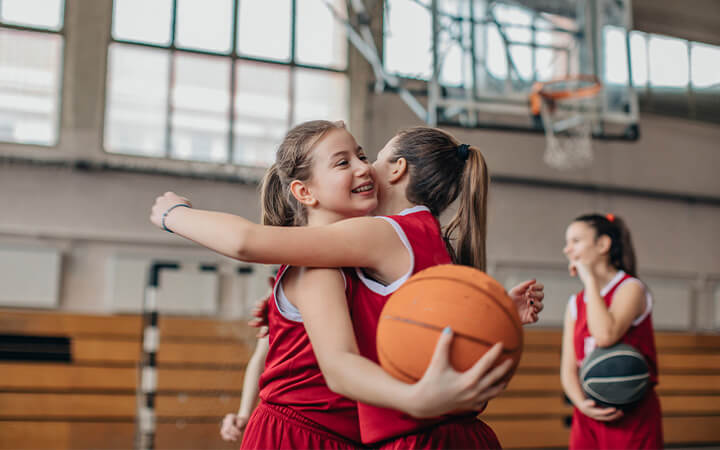 Girl-basketball-players-hugging-on-court