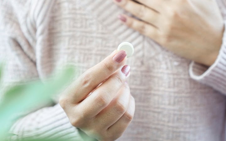 Woman holding a chewable antacid