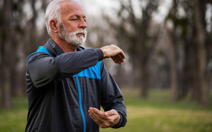 An active senior practices Tai Chi in a park
