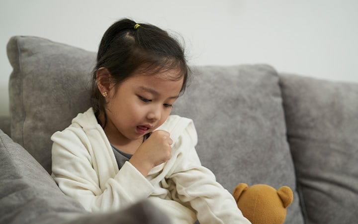 Young girl coughs