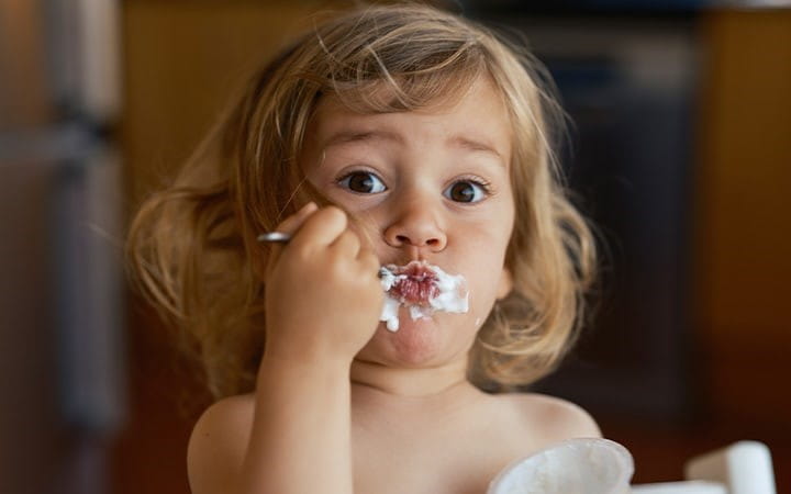 Child eats yogurt