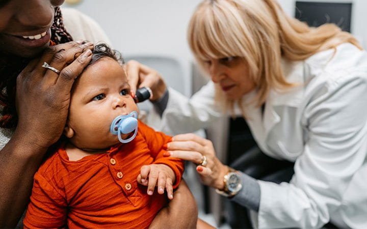 Doctor examines baby's ears