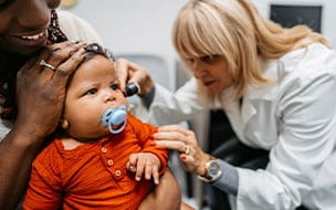 Doctor examines baby's ears