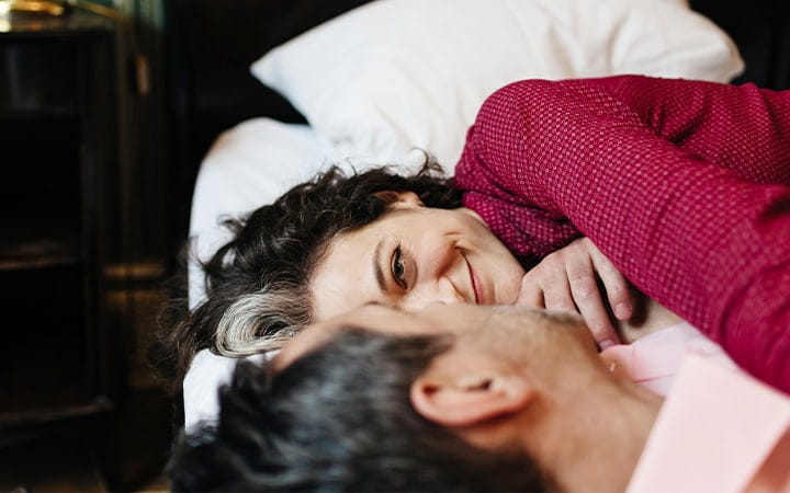 Smiling couple lying in bed
