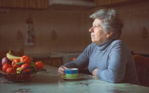 Older woman drinking coffee alone