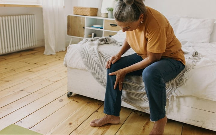 Woman clutching her knee in pain