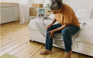 Woman clutching her knee in pain