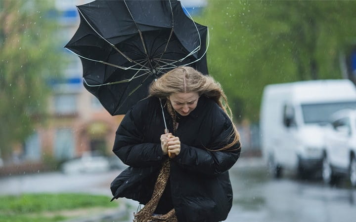 Woman walking in heavy rainstorm