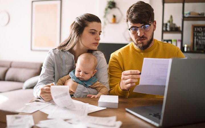 Young couple with baby review bills