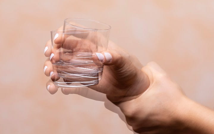 Woman holding a glass with shaky hands