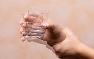 Woman holding a glass with shaky hands