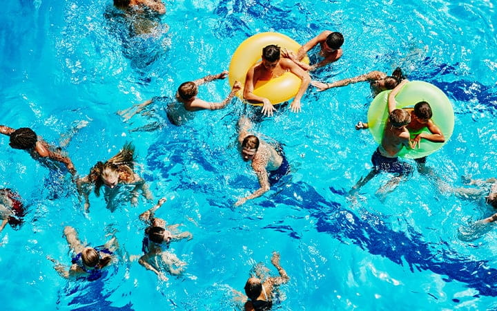 A group of kids playing together in an outdoor pool