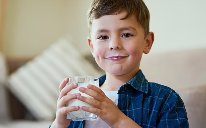 A little boy drinking milk at home