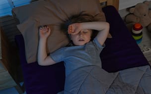 A little boy snoring while sleeping in bed at night