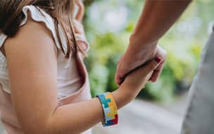 An autistic child holding hands with her mother