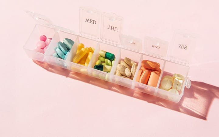 A pills organizer with tablets, vitamins, painkillers, medications and dietary supplements