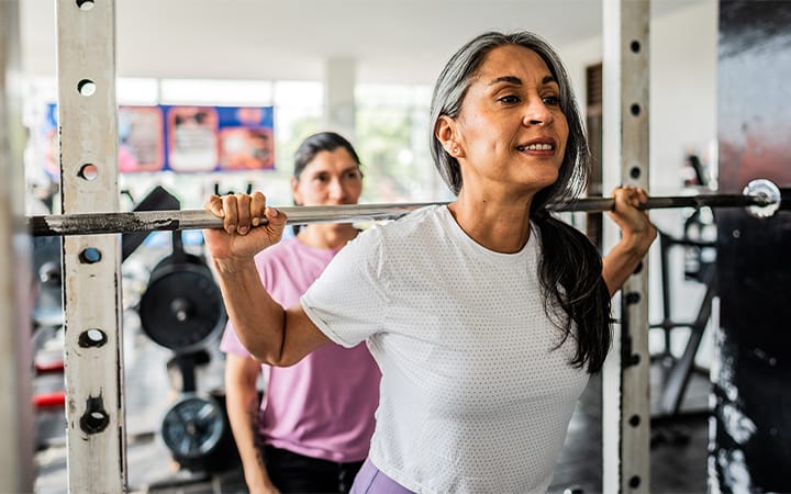 A mature woman doing weight exercises at a gym