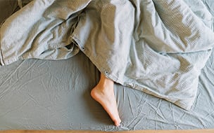 The lower half of a woman lying in bed