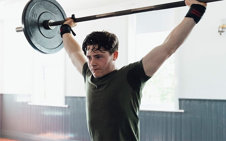 Teen boy lifting weights at gym