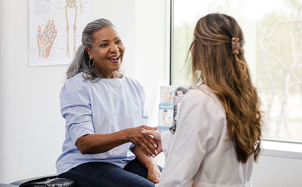 Female patient shakes hands with the female healthcare professional