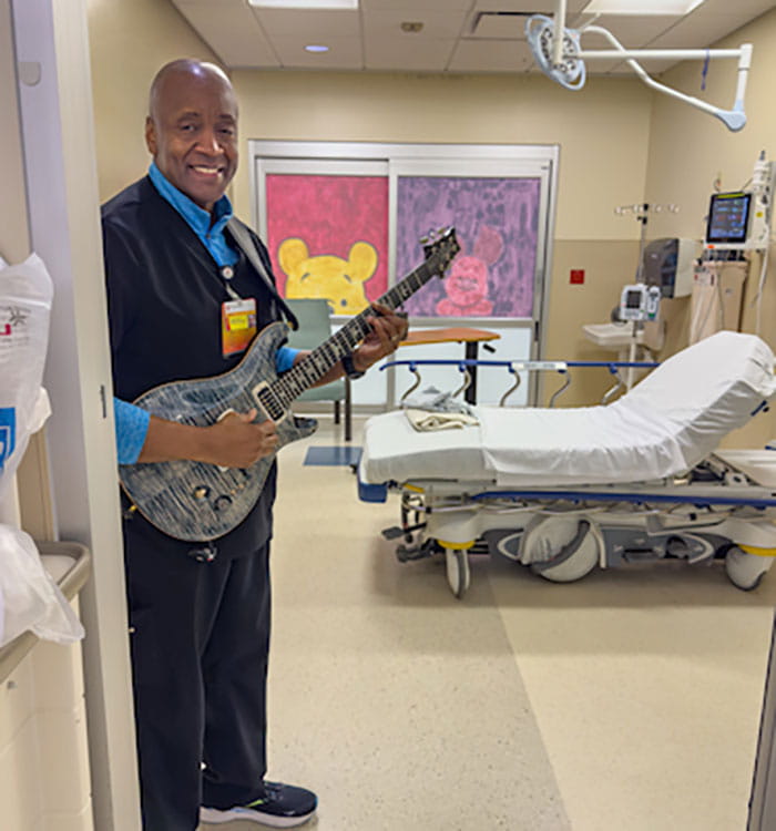 University Hospitals is conducting the ED-ALTO study of alternatives to opioids in the ED. Pictured here in the UH Cleveland Medical Center ED is UH music therapist John Pearson