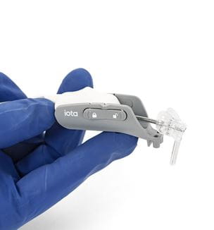 Blue gloved hand holding an Iotamotion Iotasoft cochlear implant robotic device.