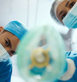 Image showing doctors in operating room getting ready to put anesthesia mask on patient.