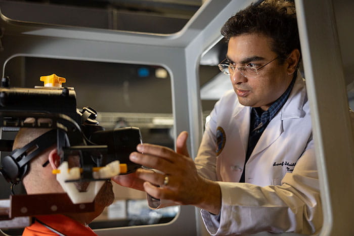 Aasef G. Shaikh, MD, PhD works with a research participant in the flight simulator at the Daroff Dell’Osso Lab.