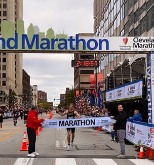 Runner going across finish line at the Cleveland Marathon race 2025.