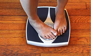 Woman on scale unhappy with her weight