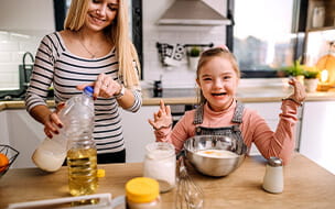 Daughter with Down syndrome helps her mother prepare pancakes