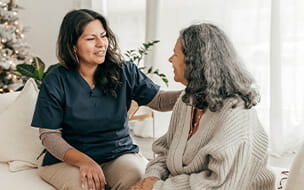 Registered Nurse assisting senior woman in her home