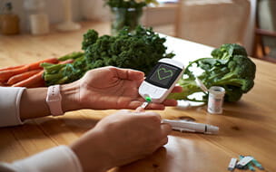 Young woman measuring her blood sugar using glucometer