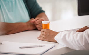 Close-up shot of female doctor giving pill box to her patient.