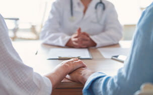 Mature couple holding hands at a doctors office