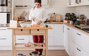 Happy woman cutting vegetables in kitchen at home