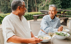 Happy elderly couple eating lunch in restaurant and enjoying bonding time