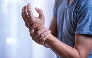 Close up of man holding wrist in pain