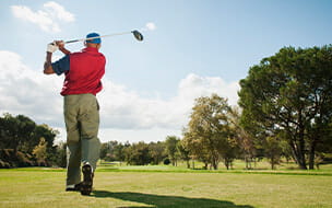 Older man playing golf on a course